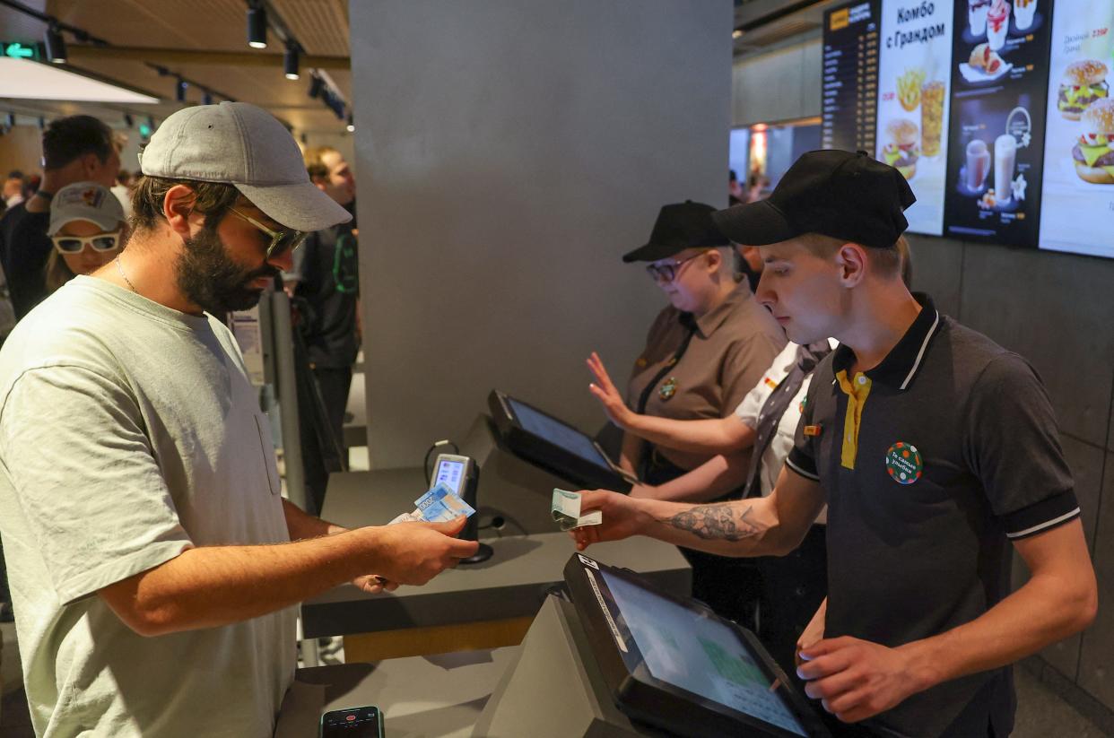 A customer seen ordering and paying for food.