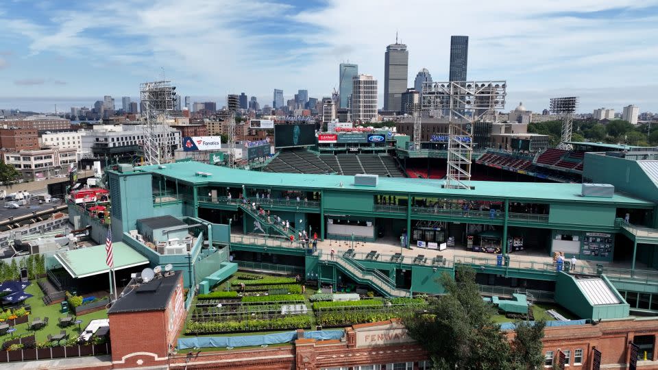 An aerial view of Fenway Park shows Fenway Farms in the foreground, against a backdrop of the Boston skyline. - Bob Crowley/CNN