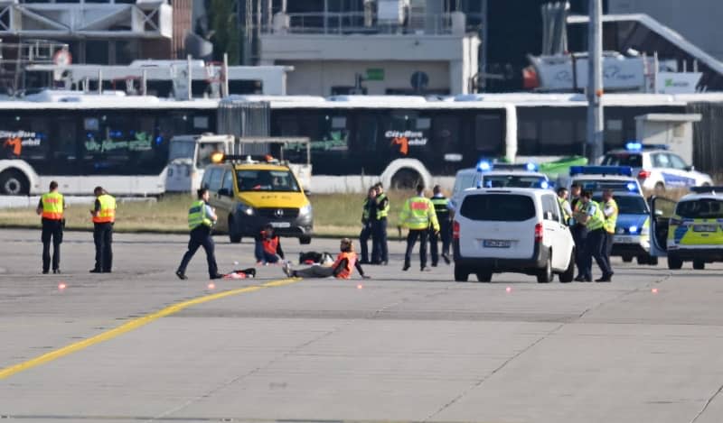 Emergency vehicles from the police, fire department and airport security are parked on the apron of Frankfurt Airport, where two activists have taped themselves up. Several demonstrators had forced their way onto the airport grounds early in the morning and stuck themselves there. As a result, air traffic was temporarily suspended. It has since been partially resumed. Arne Dedert/dpa