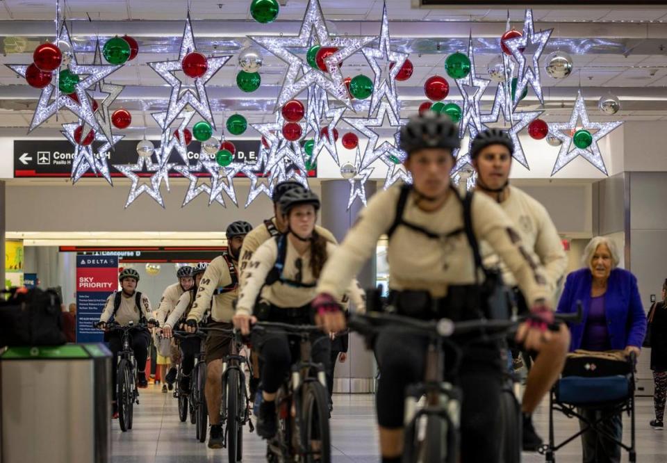 Miami, Florida, November 16, 2023 - Miami-Dade County Police officers ride their bicycles through the terminal at Miami International Airport, preparing for the coming holiday rush.
