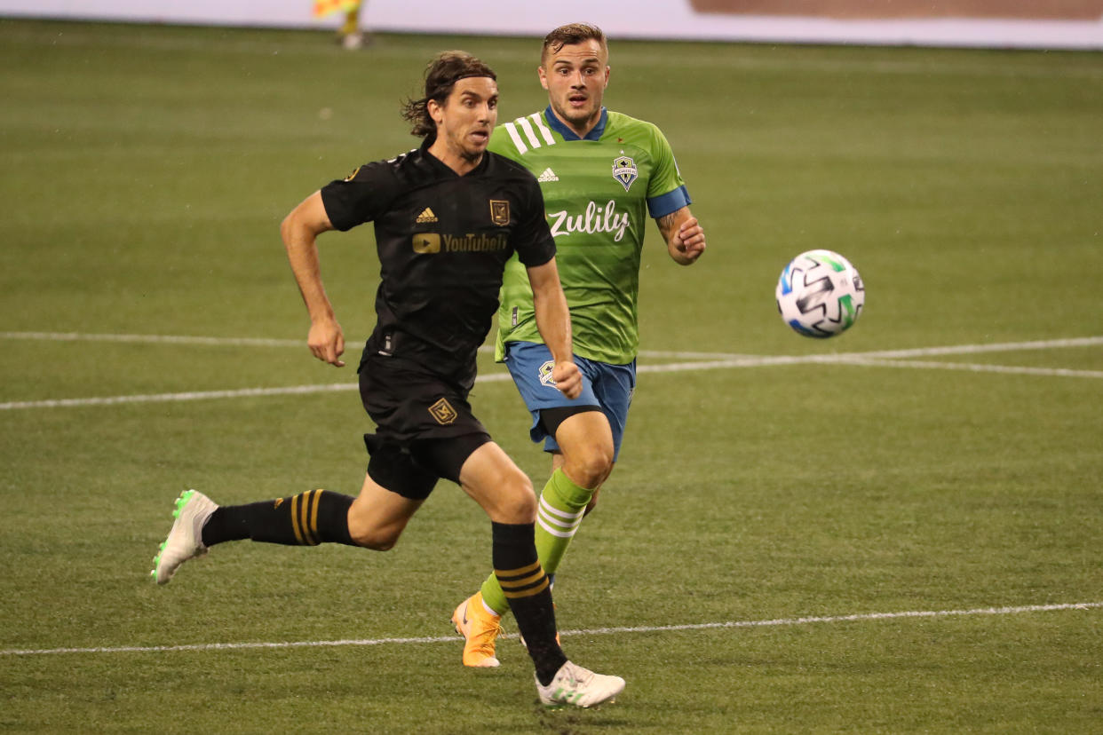 SEATTLE, WASHINGTON - AUGUST 30: Dejan Jakovic #5 of Los Angeles FC and Jordan Morris #13 of Seattle Sounders chase the ball in the second half at CenturyLink Field on August 30, 2020 in Seattle, Washington. (Photo by Abbie Parr/Getty Images)