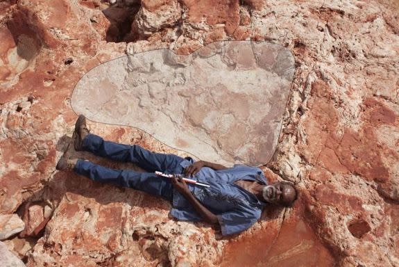 Richard Hunter lies next to a 5.5-foot-long sauropod footprint.