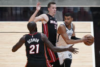 Brooklyn Nets guard Timothe Luwawu-Cabarrot, right, looks for an opening past Miami Heat center Dewayne Dedmon, left, and forward Duncan Robinson, center, during the first half of an NBA basketball game, Sunday, April 18, 2021, in Miami. (AP Photo/Wilfredo Lee)
