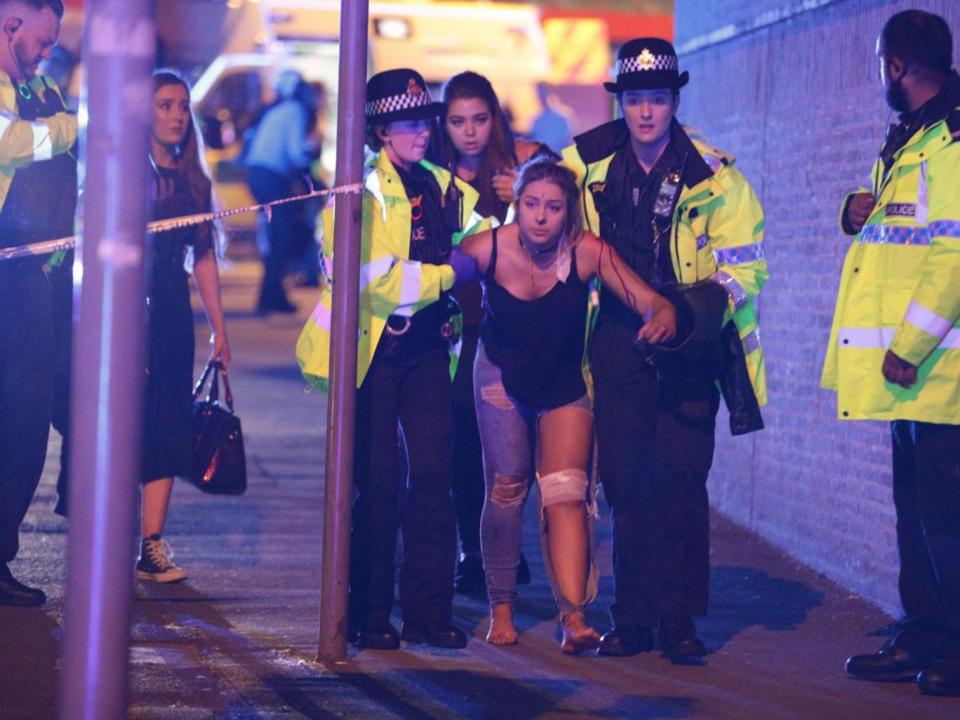 An injured woman is helped by emergency services in Manchester (London News Pictures)
