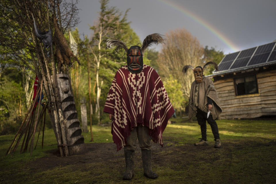 Mapuches con máscaras ceremoniales (kollon) fotografiados frente a su casa en Carimallín (Chile) el 1ro de julio del 2022. Deben espantar las energías negativas durante los festejos del año nuevo mapuche (We Tripantü). (AP Photo/Rodrigo Abd)