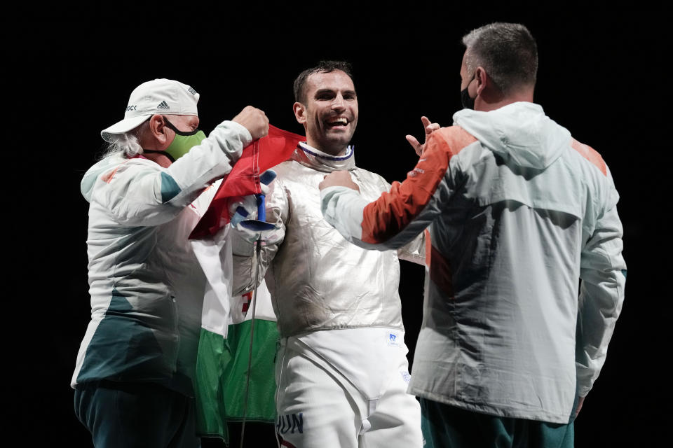 Aron Szilagyi of Hungary, center, celebrates with his staff after winning the gold in the men's individual final Sabre competition at the 2020 Summer Olympics, Saturday, July 24, 2021, in Chiba, Japan. (AP Photo/Andrew Medichini)