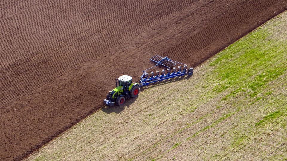 Ein Landwirt pflügt ein abgeerntetes Feld in Mecklenburg.