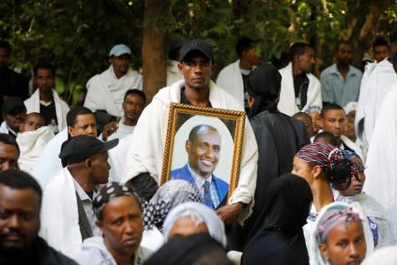A mourner holds the photo of Amhara president Mekonnen during a funeral ceremony in the town of Bahir Dar