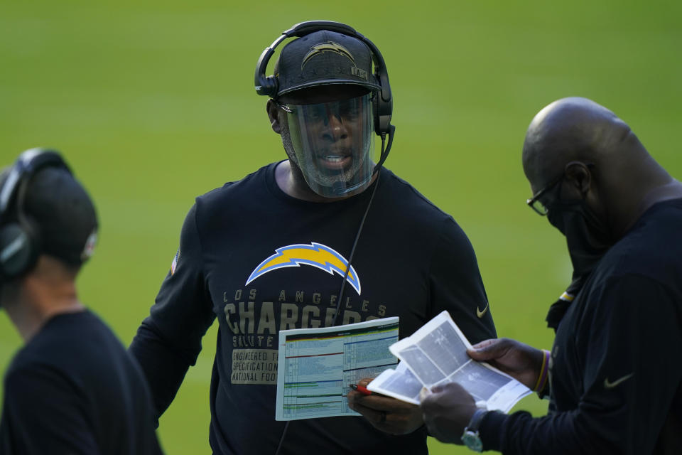 Los Angeles Chargers head coach Anthony Lynn, center, talks to his staff on the sidelines during the first half of an NFL football game against the Miami Dolphins, Sunday, Nov. 15, 2020, in Miami Gardens, Fla. (AP Photo/Lynne Sladky)