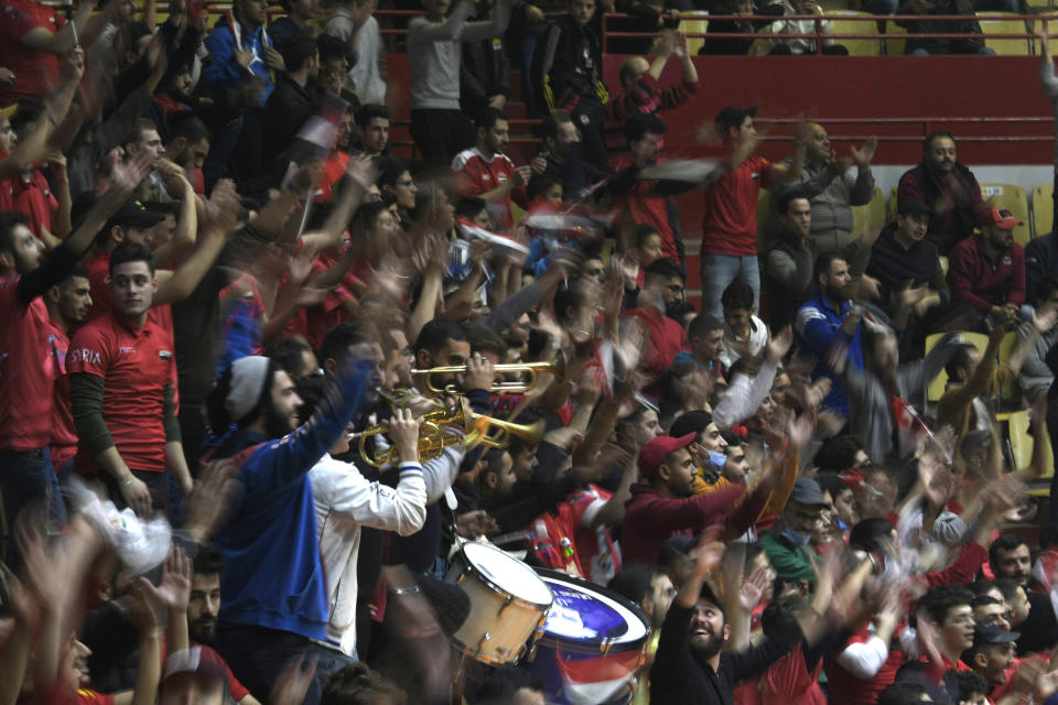 Syrian basketball fans cheer during the FIBA Basketball World Cup 2023 Asian Qualifiers Group D match between Syria and Kazakhstan, in Damascus, Syria, Monday, Nov. 29, 2021. Syria hosted the first international athletic tournament on its soil in at least two decades Monday, bringing an Asia region World Cup qualifying game to a packed stadium in the capital Damascus. The game with Kazakhstan, which Syria lost 81-71, saw the national team play at home before fans for the first time since the civil war in Syria disrupted security and upended regular life in the country. (AP Photo/Omar Sanadiki)