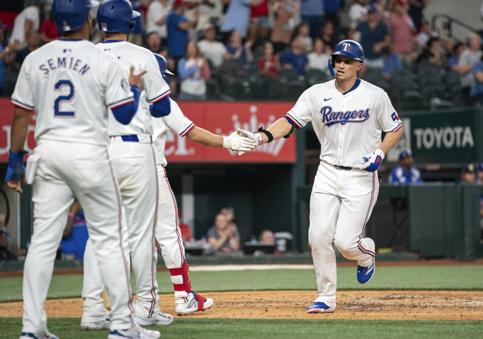 Texas Rangers' Corey Seager is congratulated by Josh Smith, Jonah Heim and Marcus Semien, left back to front, after his three-run home run that off Arizona Diamondbacks starting pitcher Brandon Pfaadt during the fifth inning of a baseball game Tuesday, May 28, 2024, in Arlington, Texas.(AP Photo/Jeffrey McWhorter)