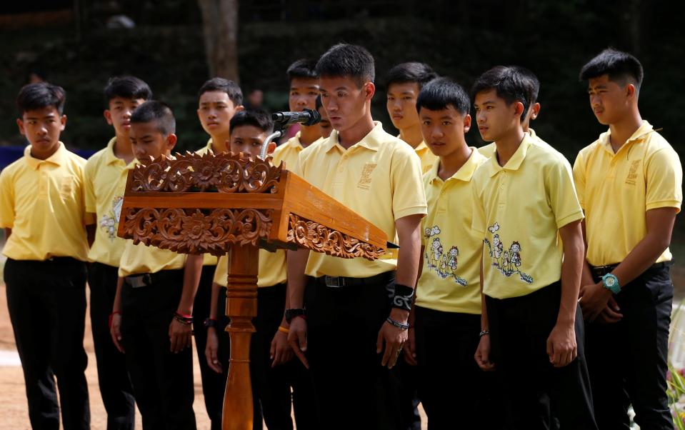 Coach Ekapol Chantawong speaks with his team during their return to Tham Luang (Reuters)