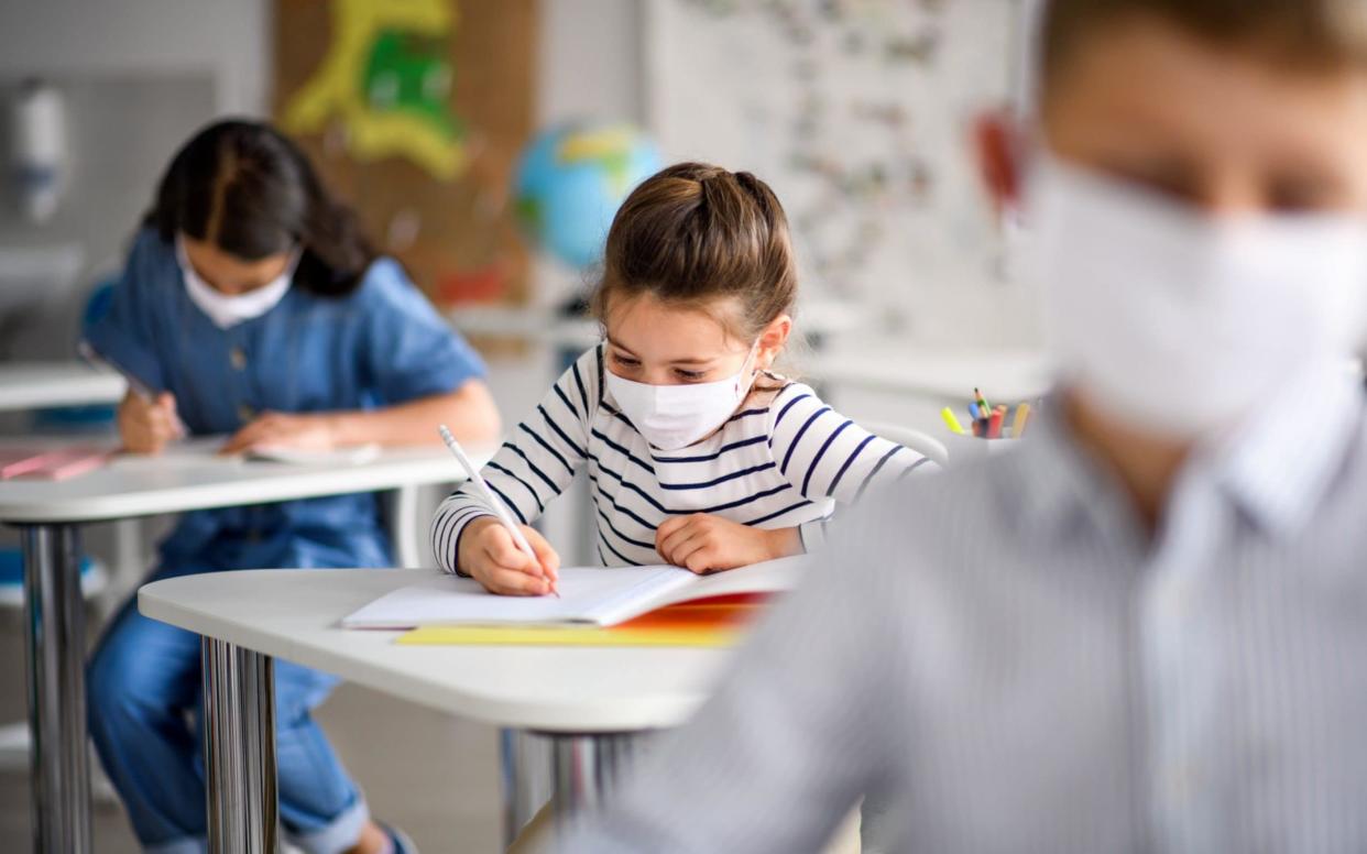 A child works at school in a face mask - Halfpoint