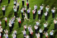 A lone streaker interrupts a marching band as they perform during the Gay Games VII opening ceremony Saturday, July 15, 2006 at Soldier Field in Chicago. The man was eventually apprehended by security as the band played on. (AP Photo/Jeff Roberson)