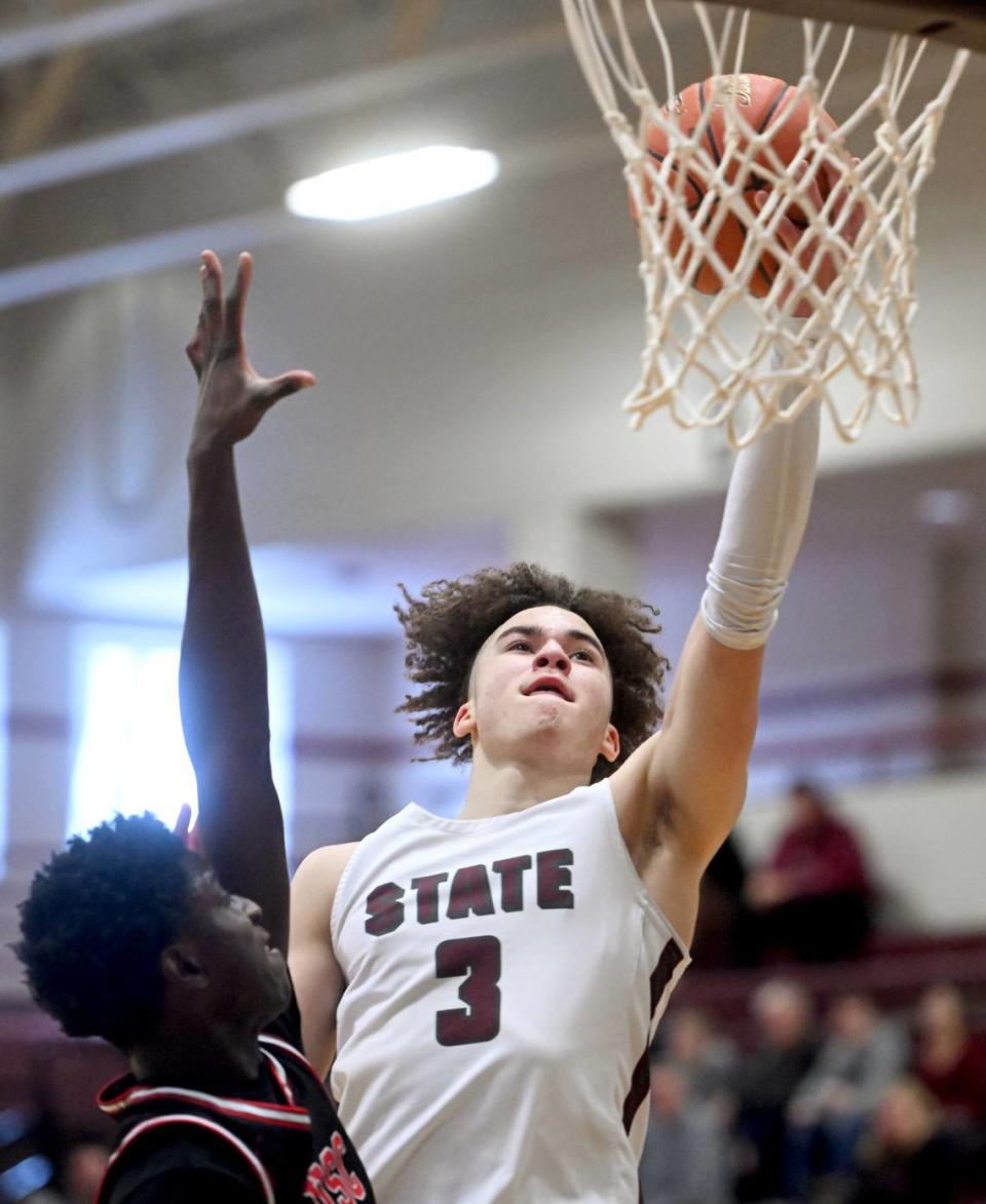 State College’s Braeden Shrewsberry goes in for a basket over an Upper St. Clair defender during the PIAA first round game on Saturday, March 11, 2023. State College won, 72-42.