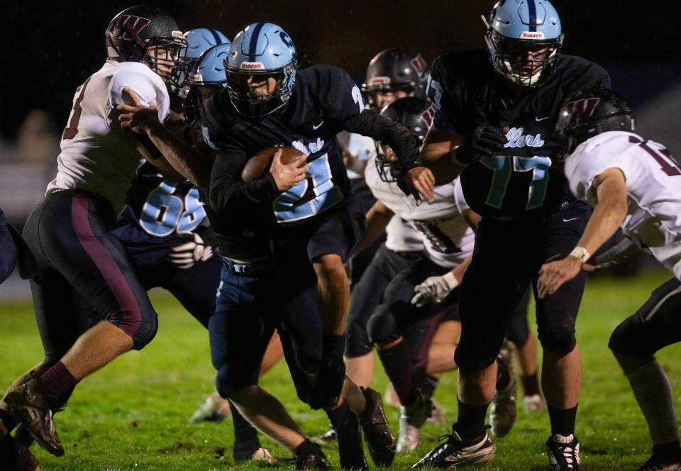 Springfield’s Connor Dye, center, rushes against Willamette during the first half of the game in Springfield on Friday, Oct. 13, 2023.