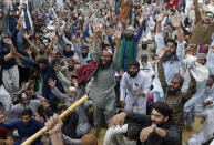 Supporters of Tehreek-e-Labiak Pakistan, a banned Islamist party, chant slogans during a protest on the arrest of their party leader Saad Rizvi, who was demanding the government to expel French ambassador, in Lahore, Pakistan, Monday, April 19, 2021. The outlawed Pakistani Islamist political group freed 11 policemen almost a day after taking them hostage in the eastern city of Lahore amid violent clashes with security forces, the country's interior minister said Monday. (AP Photo/K.M. Chaudary)