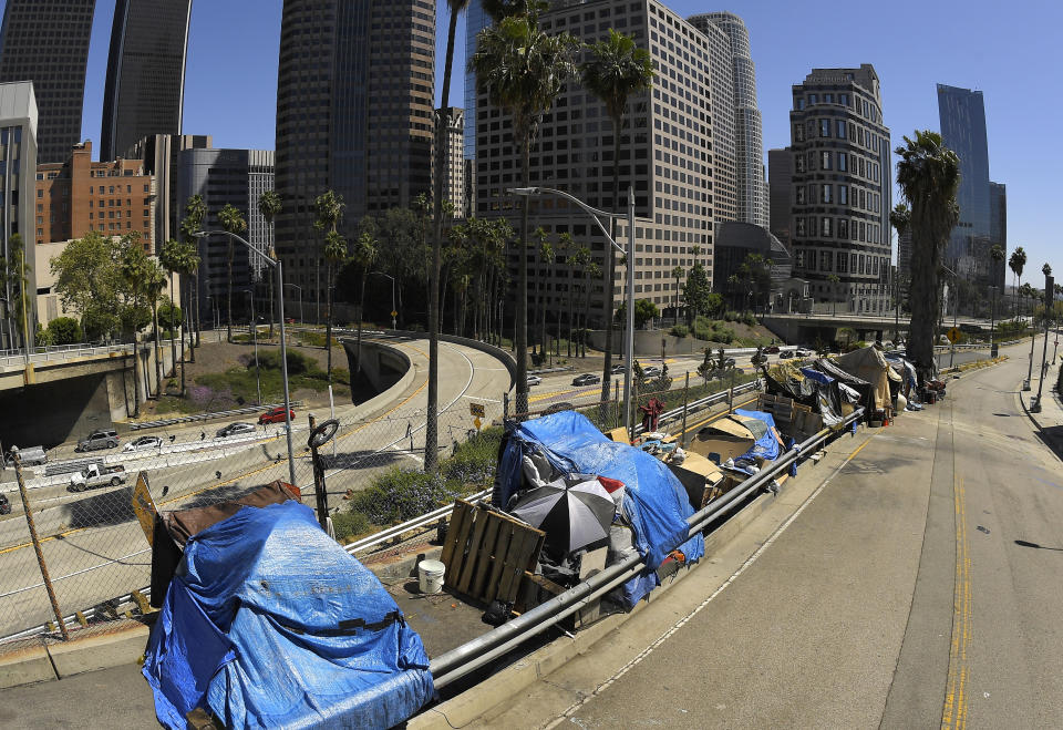 FILE - This May 21, 2020, photo, shows a homeless encampment on Beaudry Avenue as traffic moves along Interstate 110 below during the coronavirus outbreak, in downtown Los Angeles. Authorities say the number of homeless people in Los Angeles County rose this year but at a much slower pace than previously and many more people left the streets for shelters. (AP Photo/Mark J. Terrill, File)