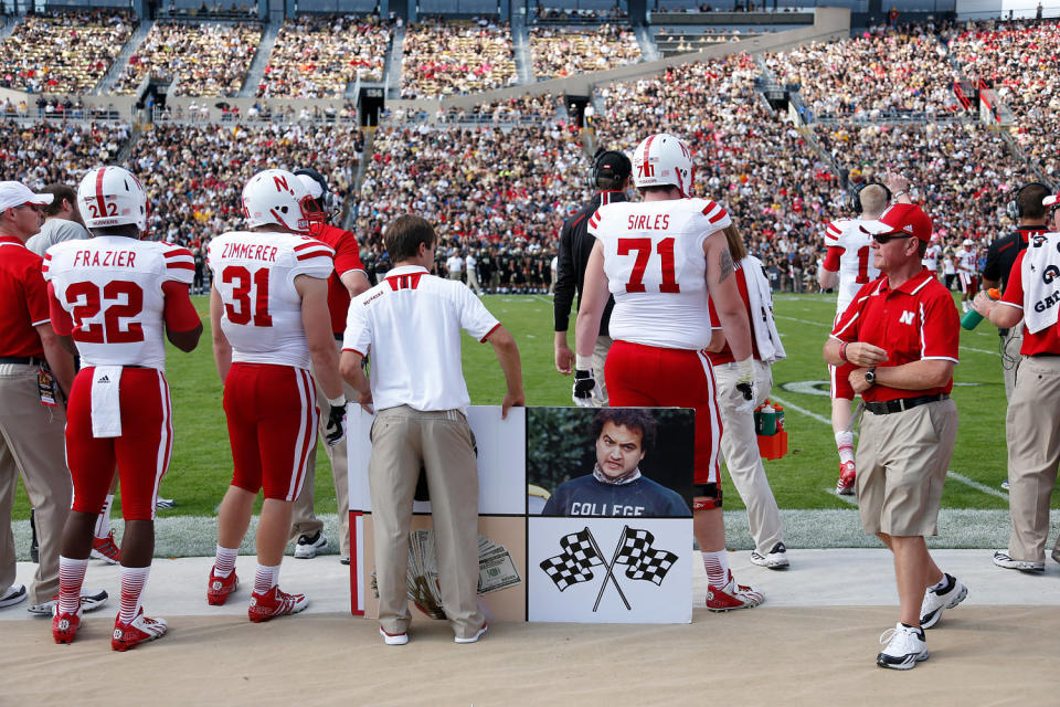 The Nebraska Cornhuskers sideline as an assistant holds a play card with a photo of John Belushi during the game against the Purdue Boilermakers  in West Lafayette, Ind., in 2013.  (Joe Robbins / Getty Images file)