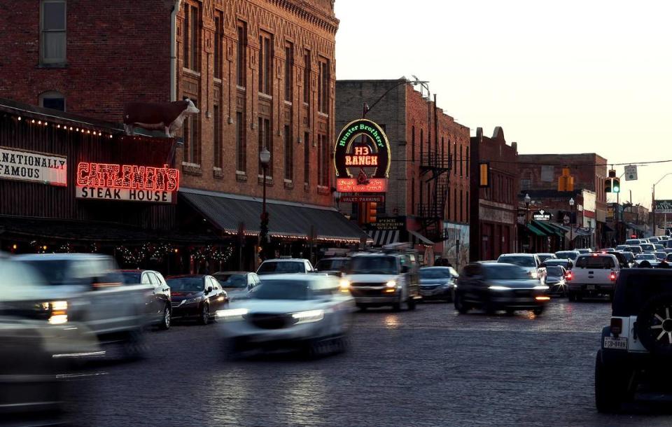 Cars drive North Main Street next to the Fort Worth Stock Yards as the sun sets. Mule Alley on Exchange Avenue in the Stock Yards has attracted many new restaurants and businesses into the area.