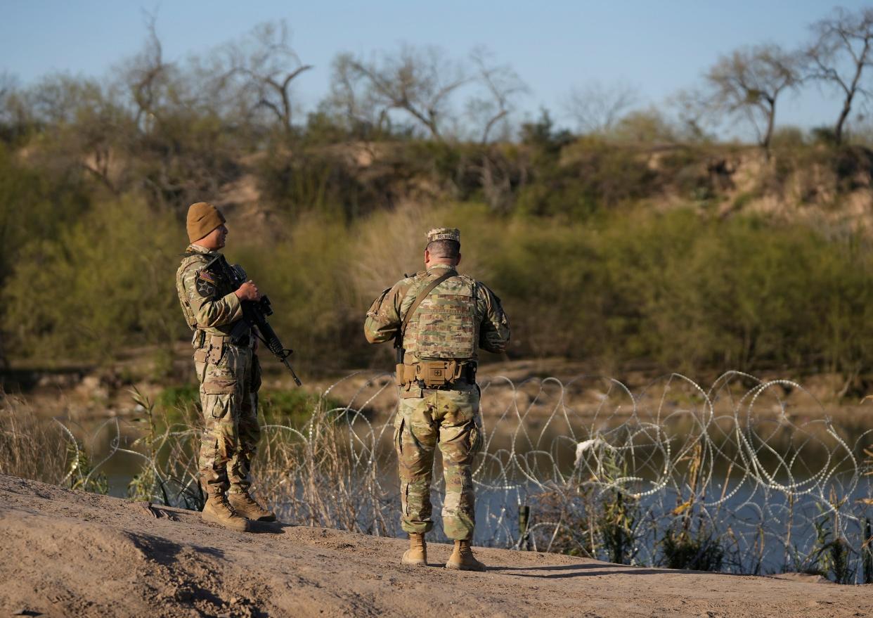 Texas National Guard troops patrol the banks of the Rio Grande in Eagle Pass on Jan. 9. Texas has denied U.S. Border Patrol agents access to 2.5 miles of the southern border in Eagle Pass.