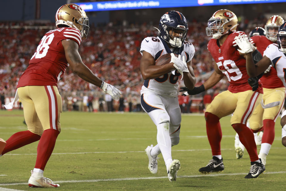 Denver Broncos running back Jaleel McLaughlin, middle, scores a touchdown between San Francisco 49ers safety Myles Hartsfield, left, and linebacker Curtis Robinson (59) during the second half of an NFL preseason football game in Santa Clara, Calif., Saturday, Aug. 19, 2023. (AP Photo/Jed Jacobsohn)