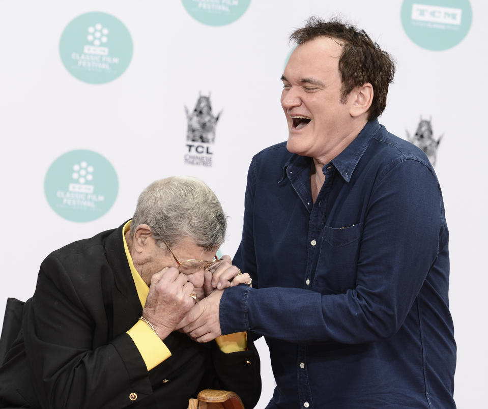 Director Quentin Tarantino reacts as actor and comedian Jerry Lewis playfully bites his hand as Lewis is honored with a hand and footprint ceremony at TCL Chinese Theatre on Saturday, April 12, 2014 in Los Angeles. (Photo by Dan Steinberg/Invision/AP Images)