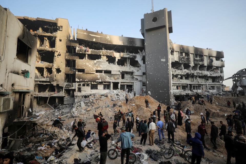 Palestinians inspect rubble surrounding Shifa hospital, where Israel claims Hamas militants hide with weapons and money (Reuters)