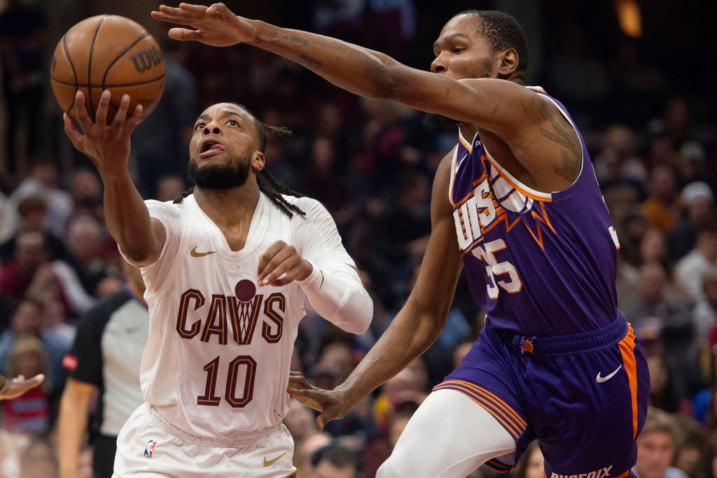 Cleveland Cavaliers' Darius Garland (10) shoots under the arm of Phoenix Suns' Kevin Durant (35) during the first half of an NBA basketball game in Cleveland, Monday, March 11, 2024. (AP Photo/Phil Long)