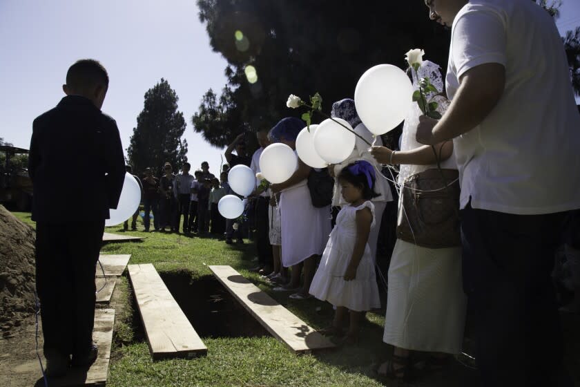 Family and friends of Moises Murillo gather at Oakdale Memorial Park for his burial service on Thursday, June 15.