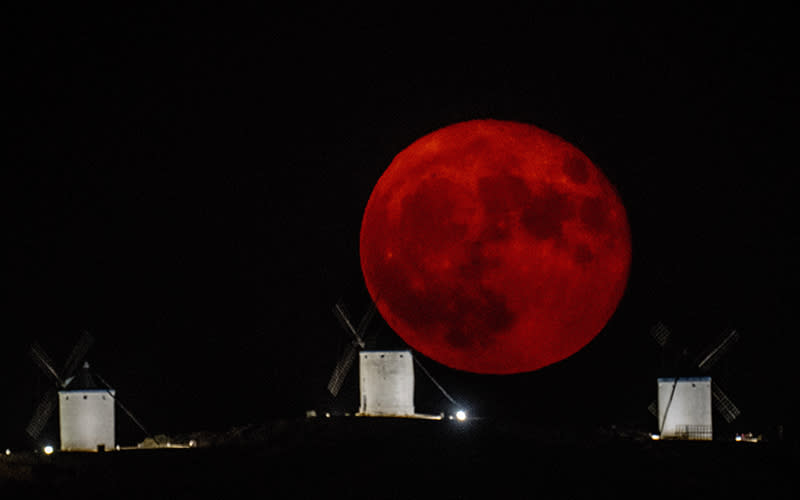 The full moon rises over a windmill