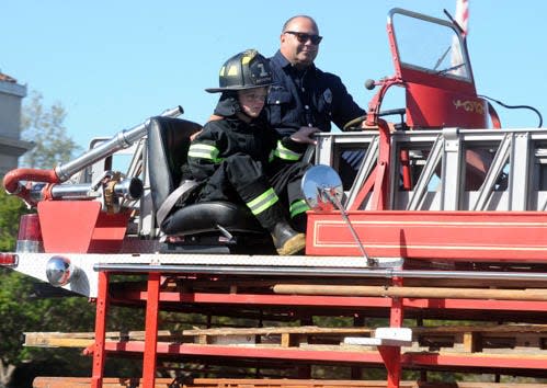 Stockton Firefighter Mario Gardea Sits With Eric Bonell, 12, On The Back Of The Antique Tiller Truck On Their Way To Engine Company 6 At Victory Park. Calixtro Romias/The Record