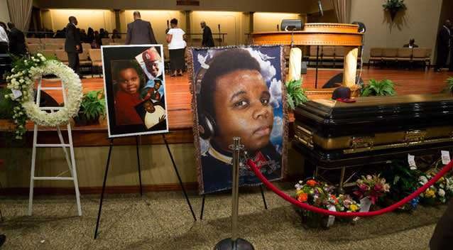 Photos surround Michael Brown's casket before the start of his funeral at Friendly Temple Missionary Baptist Church on Aug. 25. Photo: Supplied