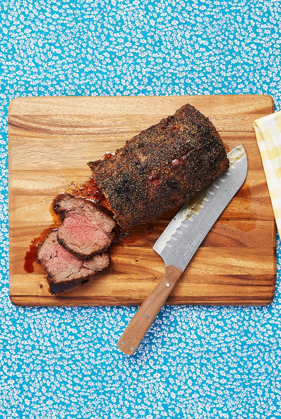 roasted beef tenderloin on carving block with knife