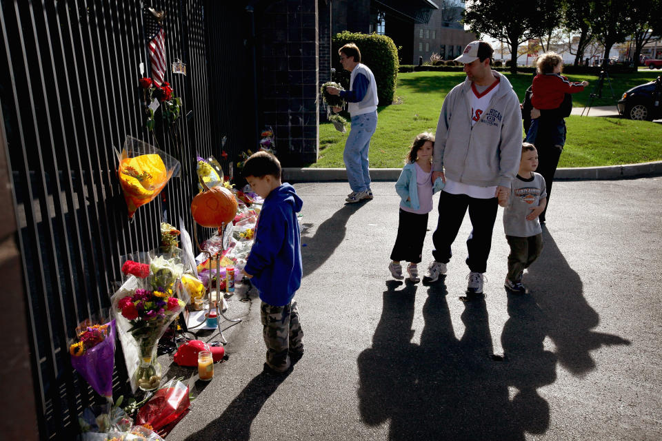 INDIANAPOLIS, IN - OCTOBER 17: Fans look over tributes to two-time Indianapolis 500 winner Dan Wheldon which have been left at a memorial at the gate of the Indianapolis Motor Speedway on October 17, 2011 in Indianapolis, Indiana. Wheldon, winner of the 2011 Indy 500, was killed in a crash yesterday at the Izod IndyCar series season finale at Las Vegas Motor Speedway. (Photo by Scott Olson/Getty Images)