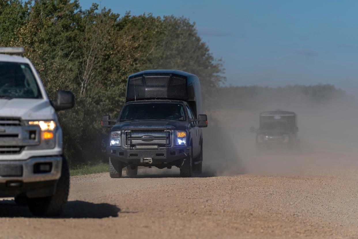 RCMP vehicles drive away from James Smith Cree Nation, Saskatchewan, on Tuesday, Sept. 6, 2022. A notice sent via Saskatchewan's emergency alert system says further investigation by RCMP has determined Myles Sanderson is not on the James Smith Cree Nation, as an earlier warning had suggested. 