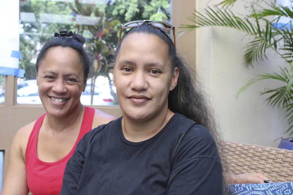 FILE - Maryann Kobatake, left, poses with her sister Melody Lukela-Singh in the lobby of the hotel where they are staying in Lahaina, Hawaii, on Aug. 31, 2023, after losing their home in a deadly fire that destroyed their historic town. They're among the residents bracing to visit the remains of their home. (AP Photo/Jennifer Sinco Kelleher, File)