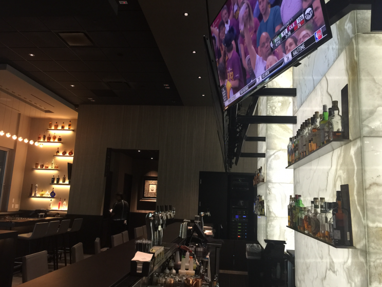 At a mostly empty The Woods, the restaurant owned by Tiger Woods, TVs were tuned to replays of the NBA playoffs. (Yahoo Sports)