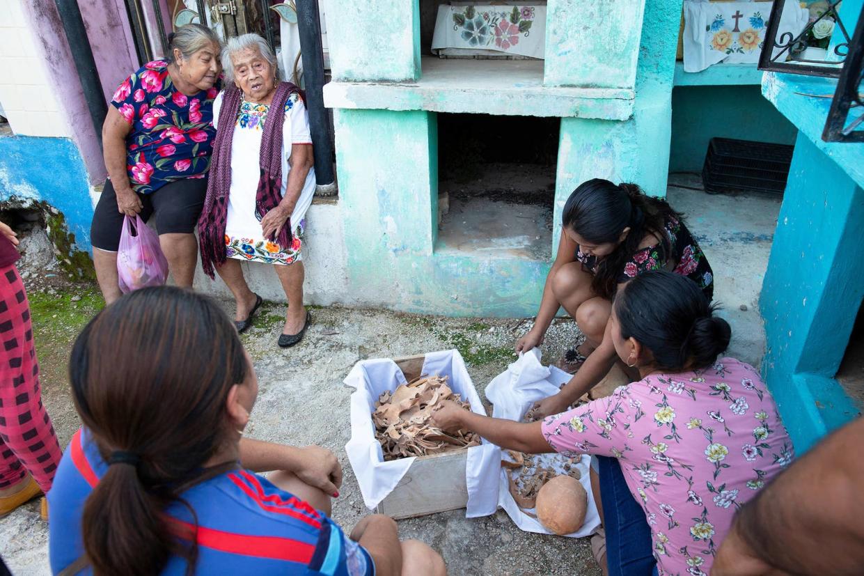 Women clean the bones and skulls of their deceased relatives from the Uitz Poot family at the cemetery of Pomuch, Campeche state, Mexico, on Oct. 22, 2022.