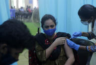 A health worker inoculates a school teacher Iram Mohammed Salim Khan with the vaccine for COVID-19 during a special drive for teachers and students in Mumbai, India, Tuesday, Sept. 28, 2021. (AP Photo/Rajanish kakade)