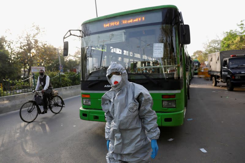 A driver wearing a protective suit walks in front of a bus carrying suspected carriers of coronavirus disease to a quarantine facility, amid concerns about the spread of coronavirus disease (COVID-19), in Nizamuddin area of New Delhi