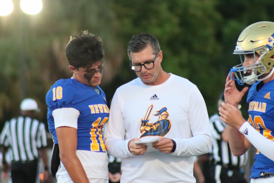 Cardinal Newman offensive coordinator Ryan Partridge goes over plays with junior receiver Jackson Miller.