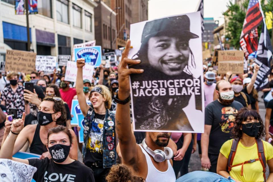 TOPSHOT - Protesters march near the Minneapolis 1st Police precinct during a demonstration against police brutality and racism on August 24, 2020 in Minneapolis, Minnesota. - It was the second day of demonstrations in Kenosha after video circulated Sunday showing the shooting of Jacob Blake -- multiple times, in the back, as he tried to get in his car, with his three children watching. (Photo by Kerem Yucel / AFP) (Photo by KEREM YUCEL/AFP via Getty Images)