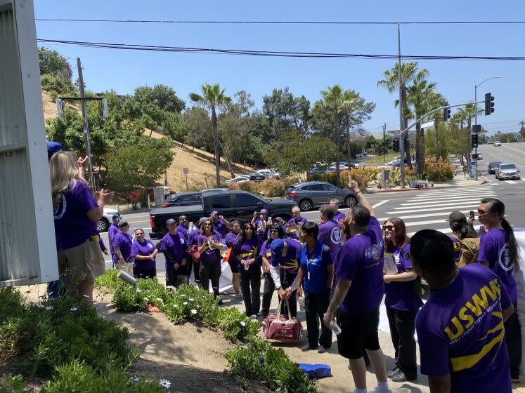 Dodger Stadium game-day workers take part in a protest on Vin Scully Avenue outside Dodger Stadium.