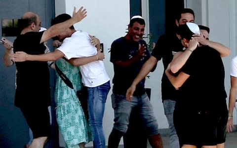 An Israeli teenager is embraced by relatives after being released from Famagusta police headquarters in southeast town of Paralimni, Cyprus, - Credit: AP