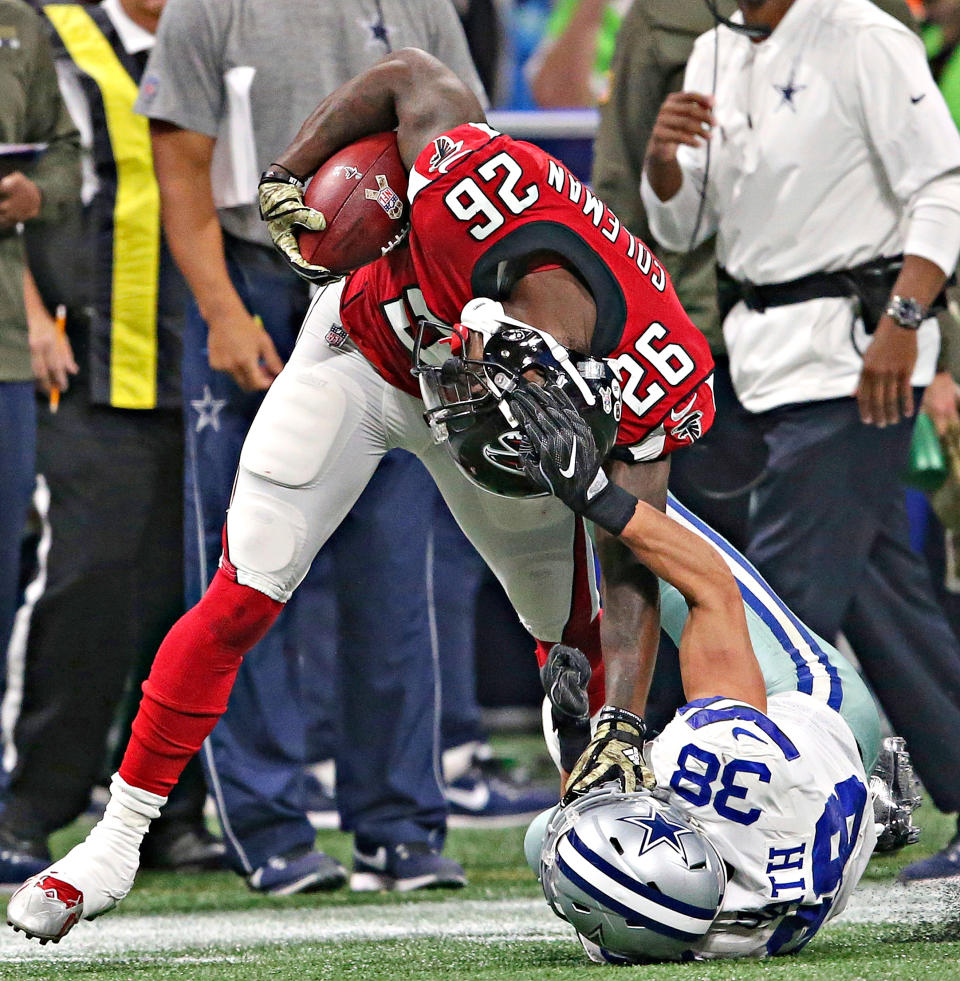 <p>Dallas Cowboys strong safety Jeff Heath (38) tackles Atlanta Falcons running back Tevin Coleman (26) by the helmet during the first half of an NFL football game, Sunday, Nov. 12, 2017, in Atlanta. Heath was hit with a personal foul on the play. (AP Photo/John Bazemore) </p>