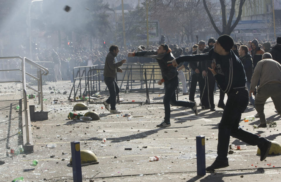 Bosnian protesters throw stones towards a local government building, during a protest, in the Bosnian town of Tuzla, Friday, Feb. 7, 2014. Bosnian protesters stormed and set ablaze local government buildings in three Bosnian cities on Friday in fury over unemployment and rampant corruption. At least 90 people were injured. (AP Photo/Amel Emric)