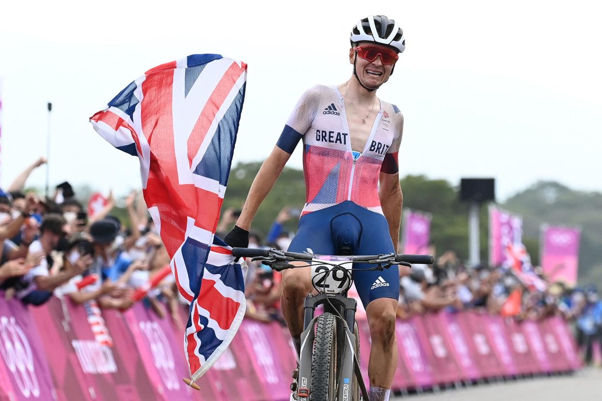 Britain's Thomas Pidcock celebrates as he crosses the finish to win the gold medal in the cycling mountain bike men's cross-country event during the Tokyo 2020 Olympic Games at the Izu MTB Course in Izu on July 26, 2021. (Photo by GREG BAKER / AFP) (Photo by GREG BAKER/AFP via Getty Images)