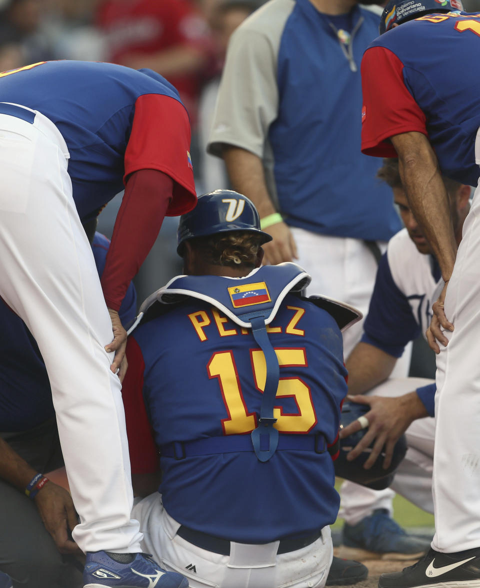 Venezuela's Salvador Perez is helped after being injured during a World Baseball Classic game against Italy, in Guadalajara, Mexico, Saturday, March 11, 2017. All-Star catcher Perez injured his left knee in a home-plate collision with his Kansas City Royals backup Drew Butera in a World Baseball Classic game. Venezuela rallied to beat Italy 11-10 on Martin Prado's 10th-inning double after Butera stumbled into Perez to end the ninth with the score tied at 10.(AP Photo/Luis Gutierrez)