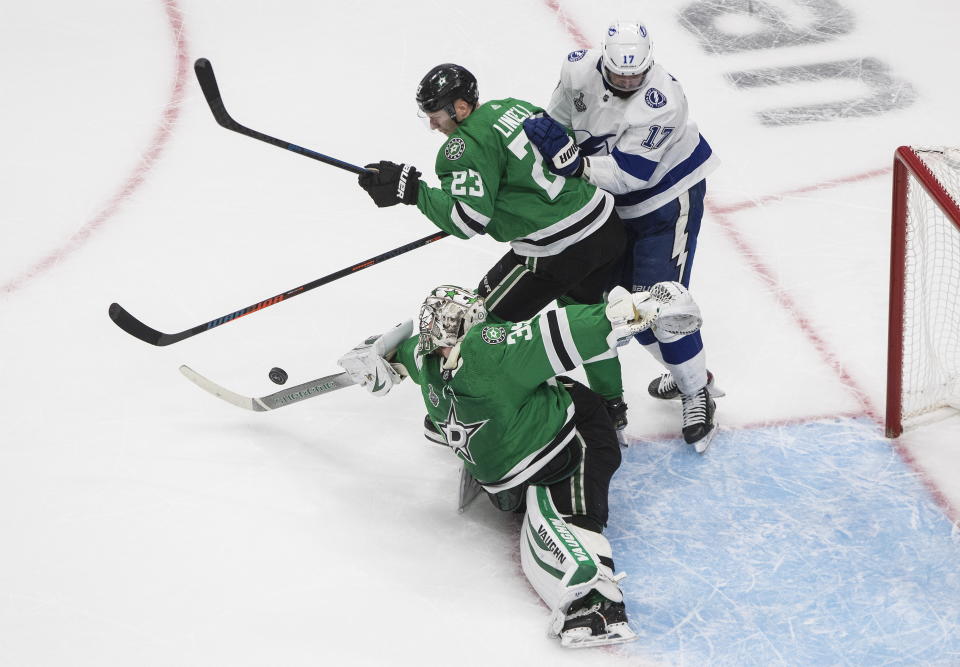 Dallas Stars goaltender Anton Khudobin (35) turns the puck away as Tampa Bay Lightning center Alex Killorn (17) and Stars defenseman Esa Lindell (23) look for the puck during the second period of Game 3 of the NHL hockey Stanley Cup Final, Wednesday, Sept. 23, 2020, in Edmonton, Alberta. (Jason Franson/The Canadian Press via AP)